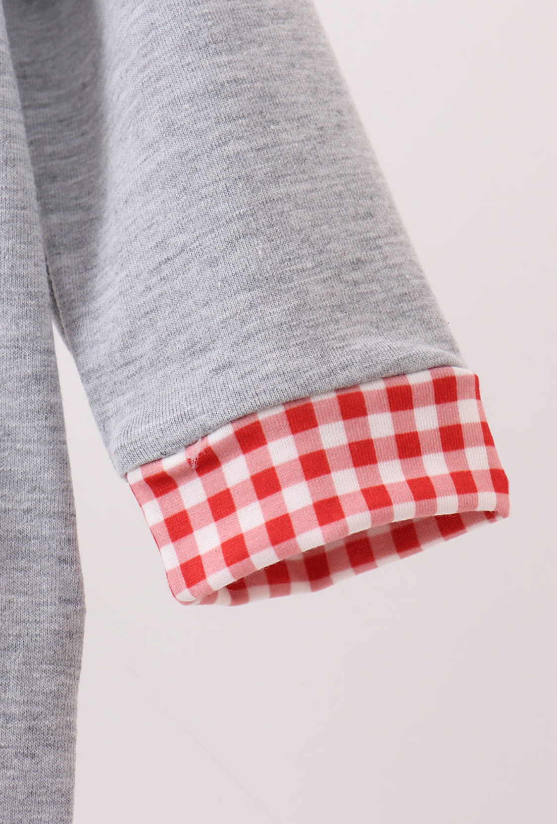 Gray fabric with red and white checkered trim on a light gray background