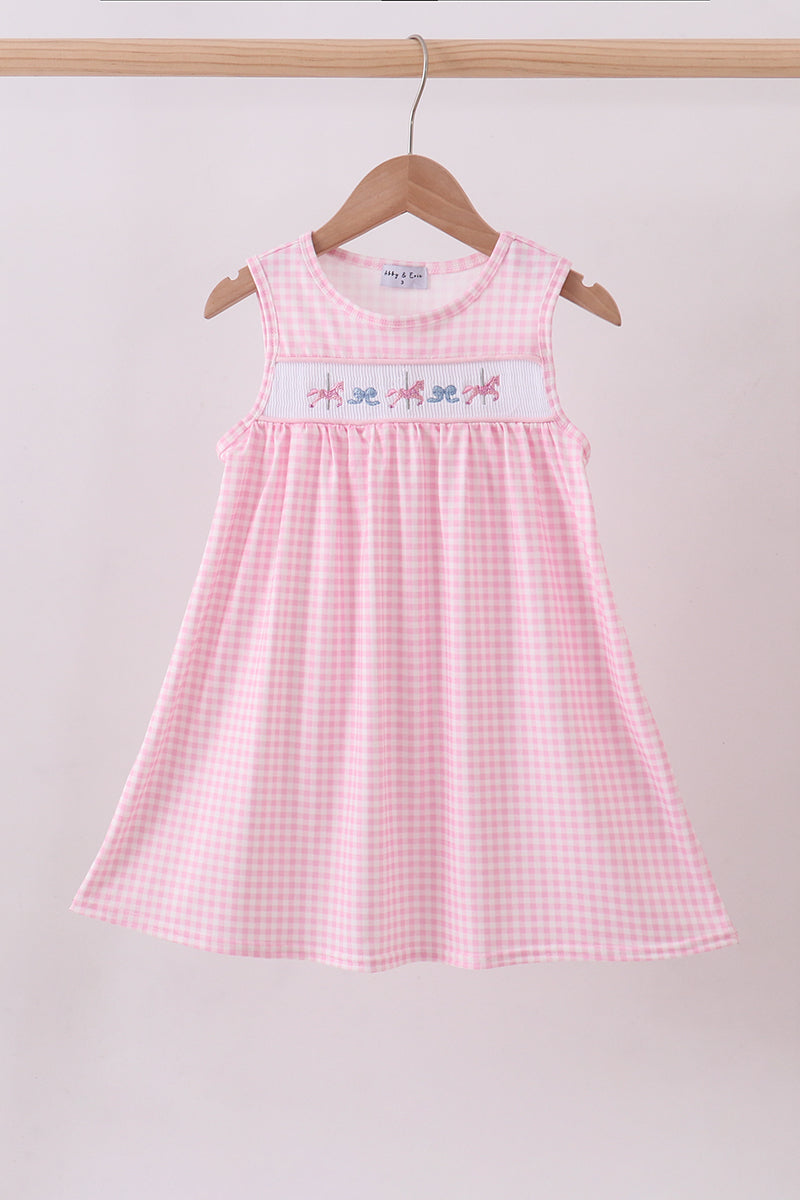 Pink checkered dress with embroidered design on a hanger against a plain background