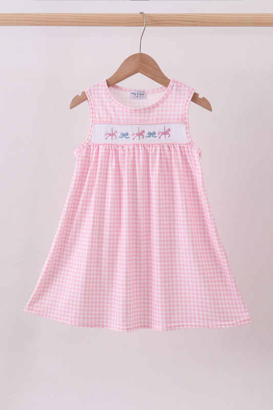 Pink checkered dress with embroidered design on a hanger against a plain background