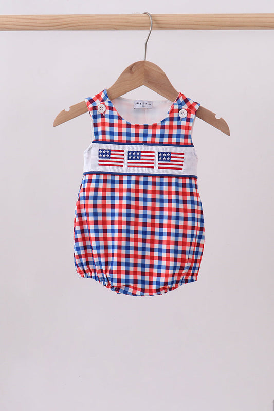 Red, white, and blue checkered baby romper with American flag design on a hanger against a light gray background.